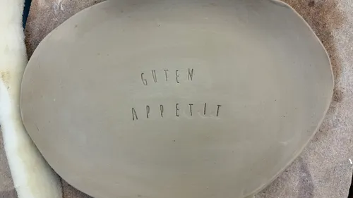 Tonteller mit Text: 'Guten Appetit'.