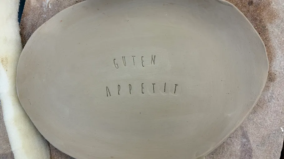Tonteller mit Text: 'Guten Appetit'.
