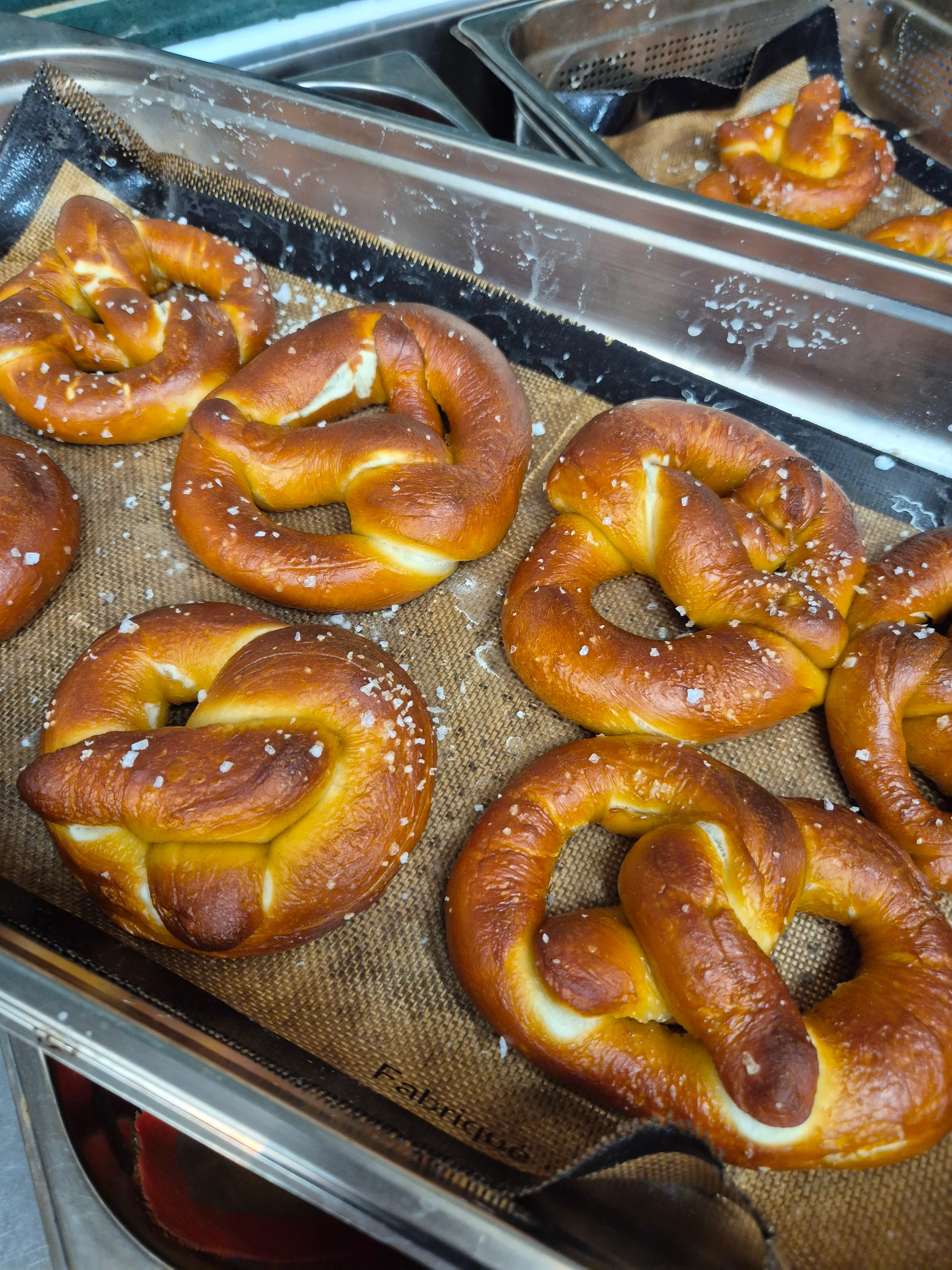 Frisch gebackene Brezeln mit Salz im Blech.