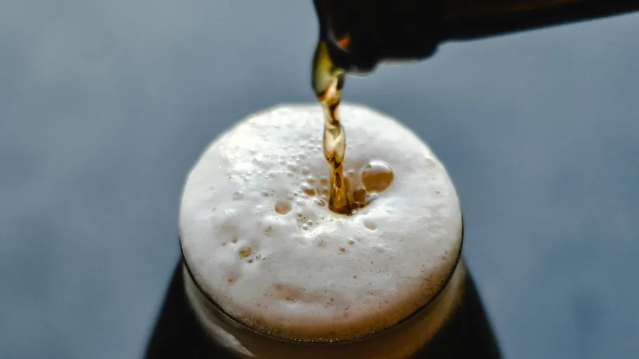 Bier wird in einen schaumigen Krug gegossen.