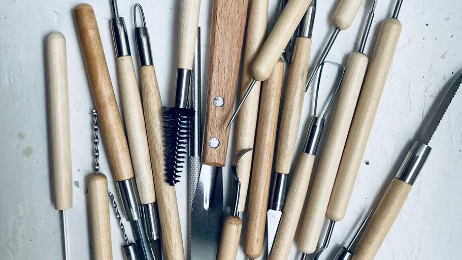 Wood-handled clay sculpting tools scattered randomly.