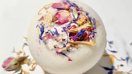 Bath bomb with colorful dried flowers on top.