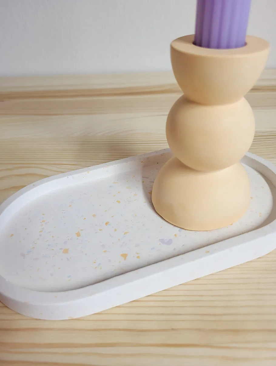 Candle holder with purple candle on tray.