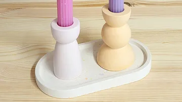 Two colorful candles on a wooden surface.