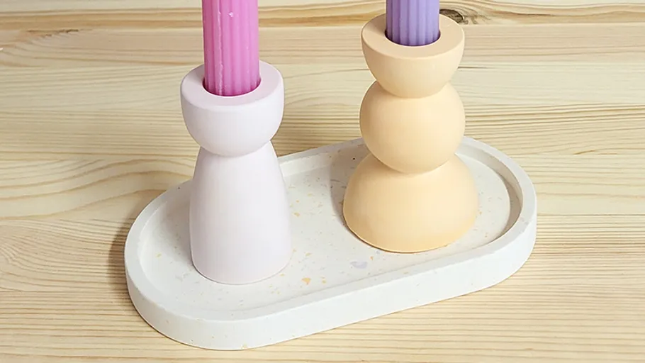 Zwei bunte Kerzen auf Holzoberfläche.