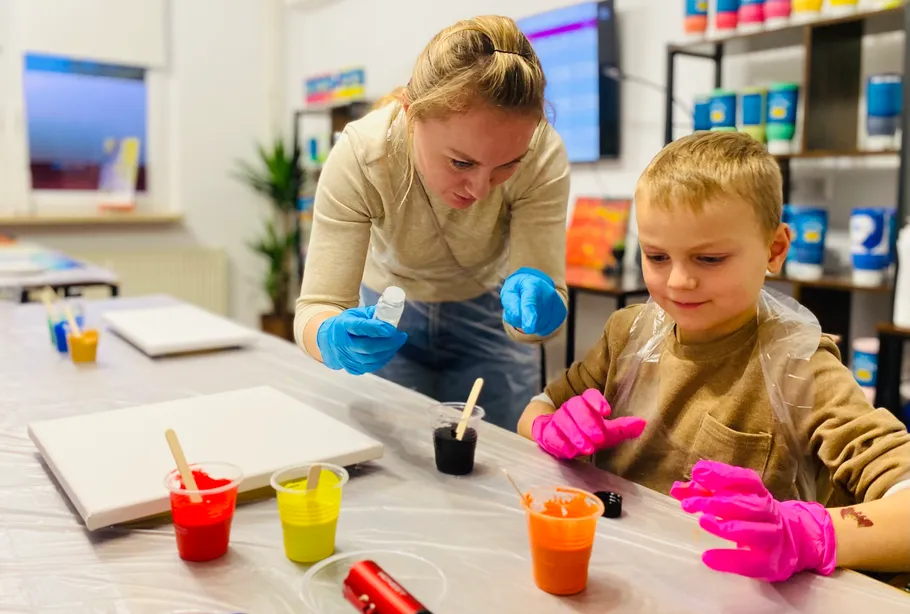 Woman and child preparing to paint in studio.