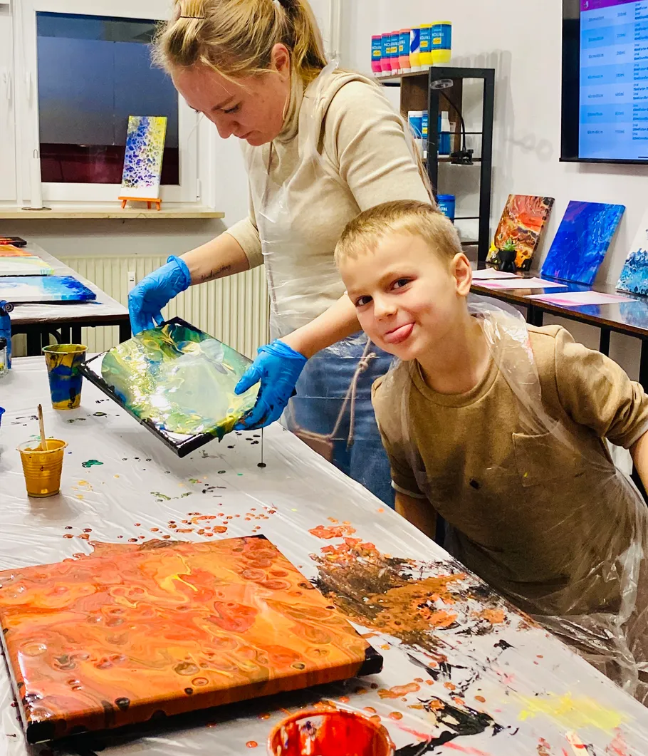 Child and woman painting in art studio.