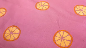 Gelbe Zitrusdrucke auf rosa Stoff.