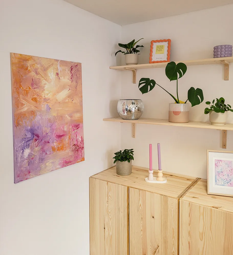 Abstract painting, shelves with plants, wooden cabinets.