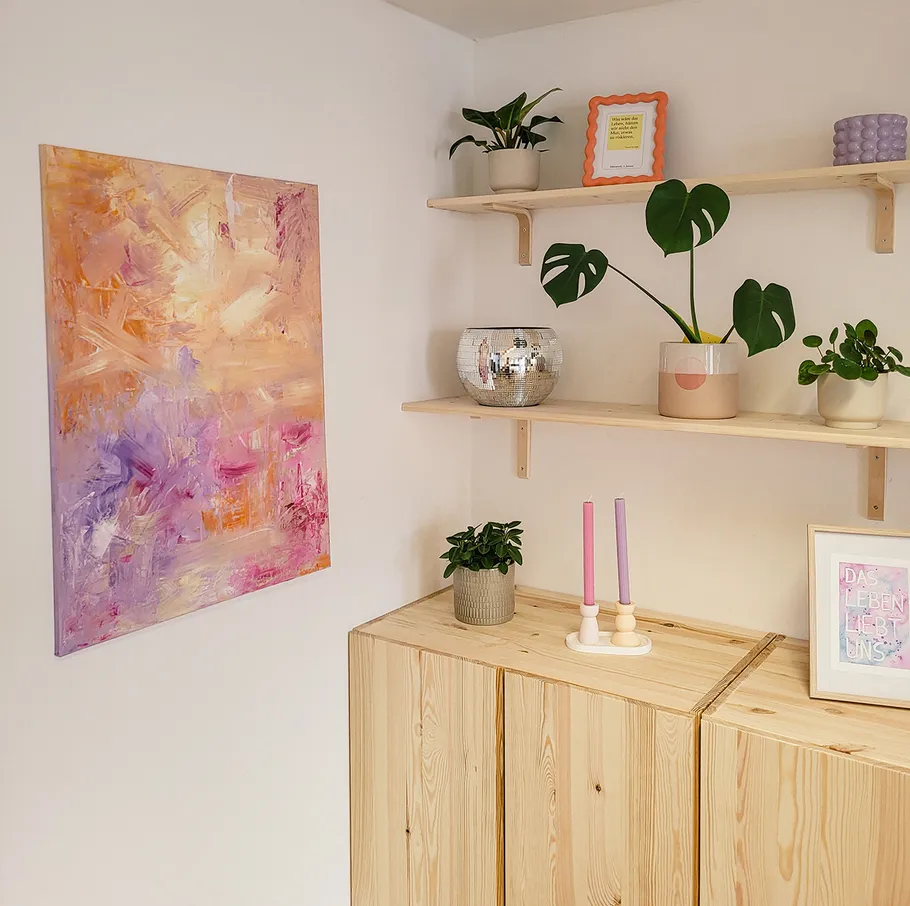 Abstract painting in modern room with plants.