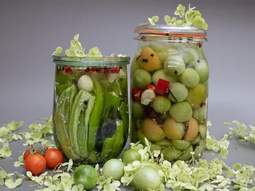 Canned vegetables and fruits in jars with decoration.