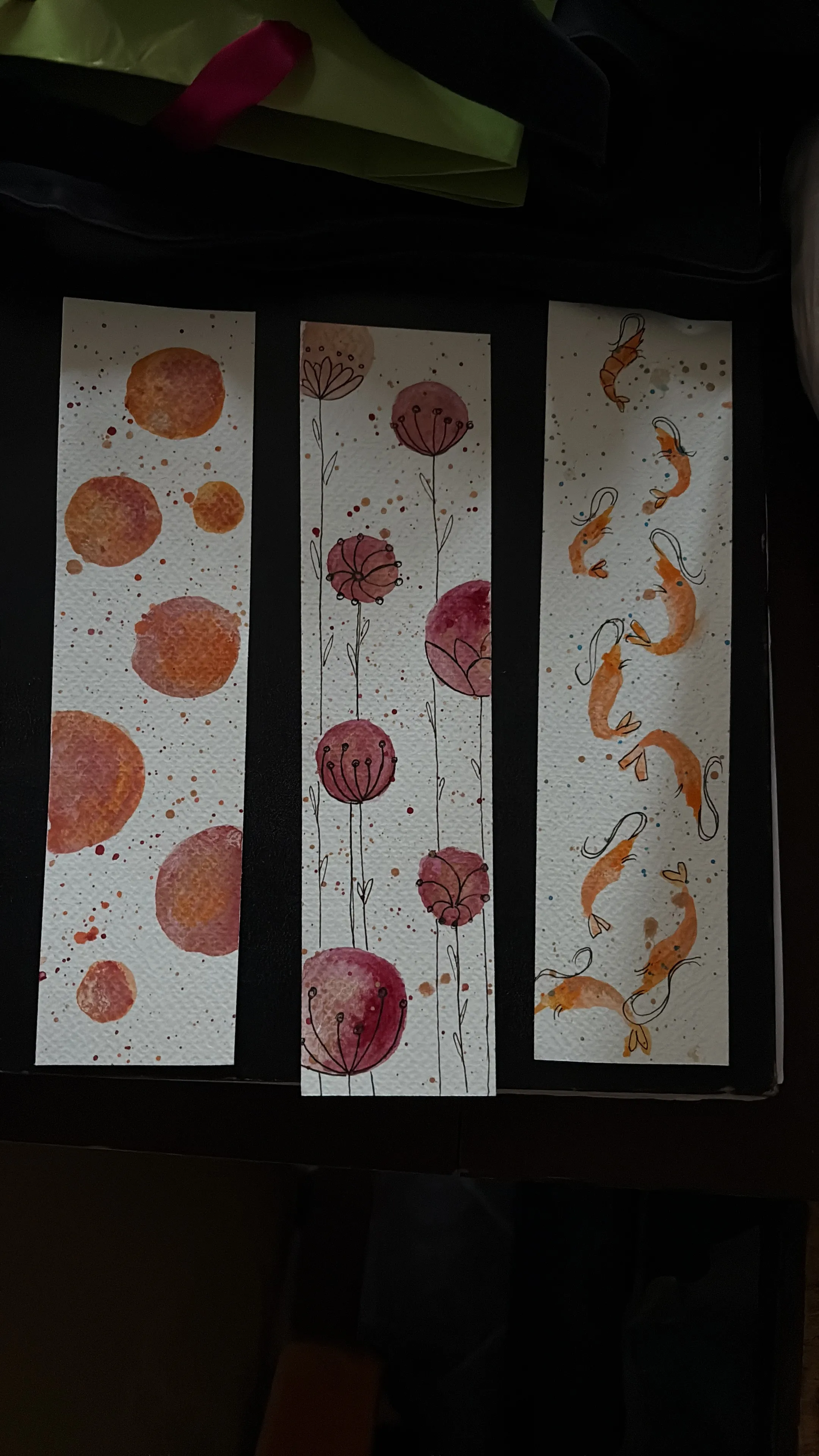 Drei Aquarell-Lesezeichen mit künstlerischen Designs.