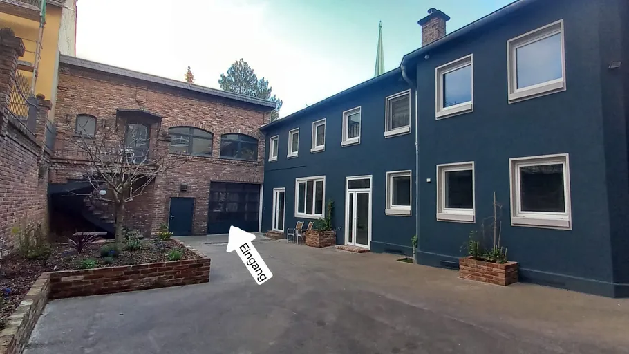 Hof mit Ziegel- und blauen Gebäuden.