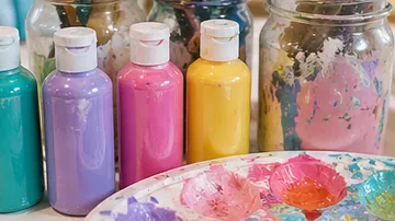 Colorful paint bottles and palette in studio.