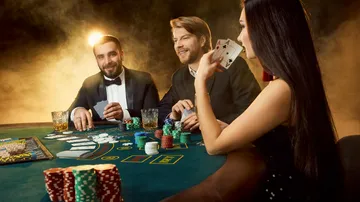 Drei Personen spielen Poker in einem Casino.