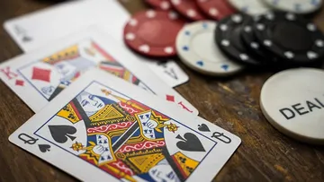 Playing cards and poker chips on table.