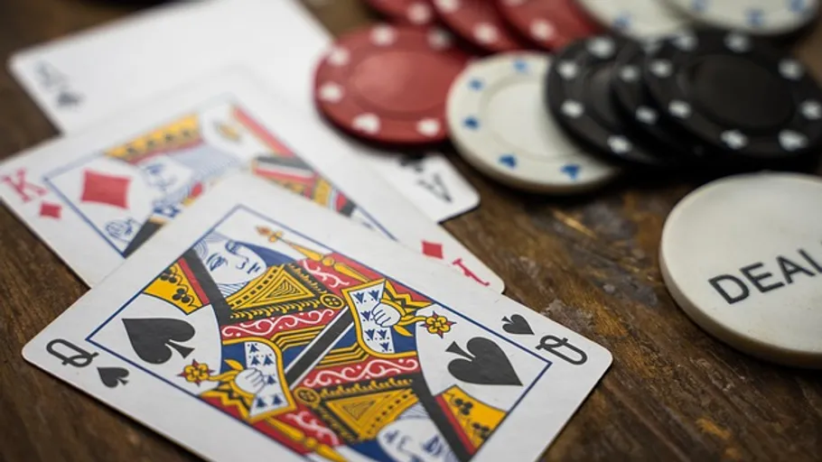 Playing cards and poker chips on table.