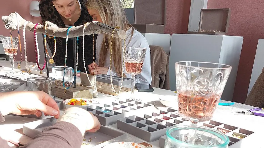 People making jewelry at a table.