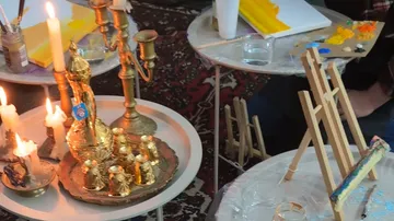 Candles and art supplies on small tables.