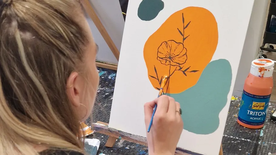Person malt Blume auf Leinwand mit Acrylfarben.