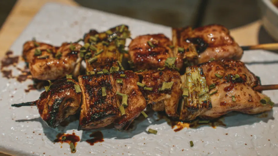 Grilled skewers with meat and vegetables on plate.