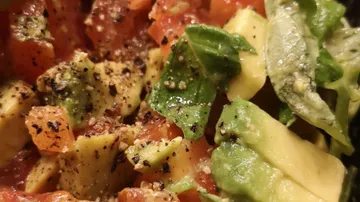 Tomaten- und Avocadosalat mit Pfeffer gewürzt.