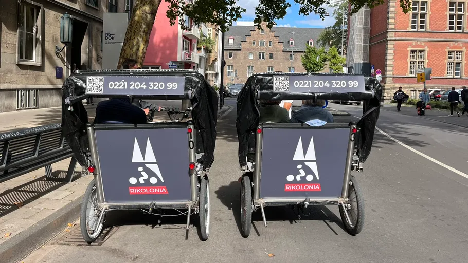Zwei Rikscha auf einer Stadtstraße geparkt.