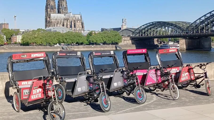 Reihe von Rikschas nahe Kölner Dom am Fluss.