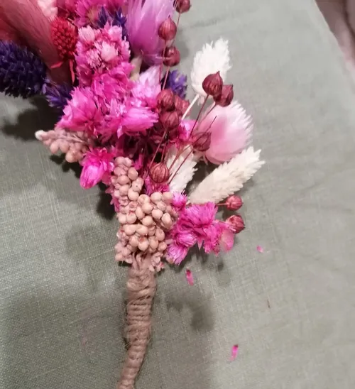 Bunter Trockenblumenstrauß auf grünem Stoff.