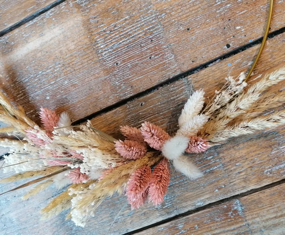 Getrocknete Blumenanordnung auf Holzboden.