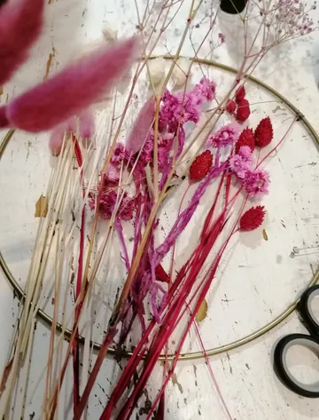 Bunte Trockenblumen auf rustikalem Tisch mit Schere.