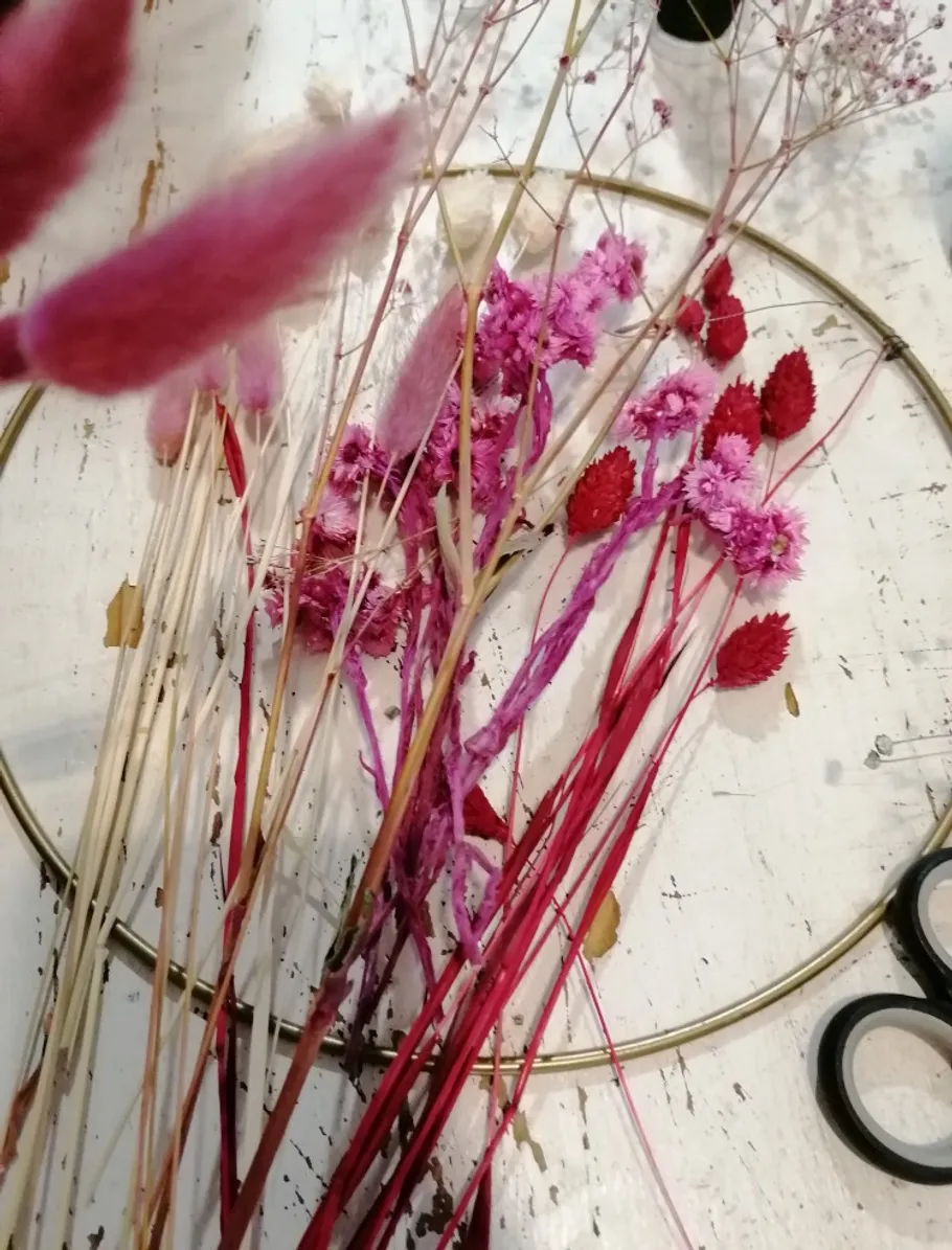 Bunte Trockenblumen auf rustikalem Tisch mit Schere.
