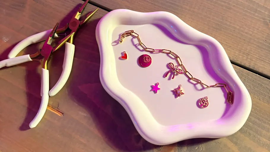 Schmuck und Werkzeuge auf weißer Schale, Holzoberfläche.