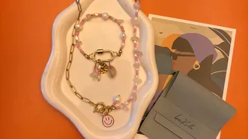 Jewelry on a dish with postcard background.