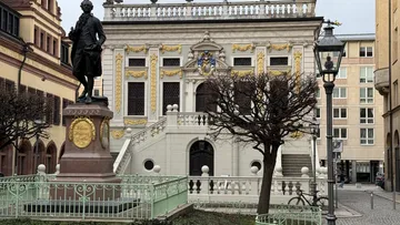 Statue in front of ornate historic building.