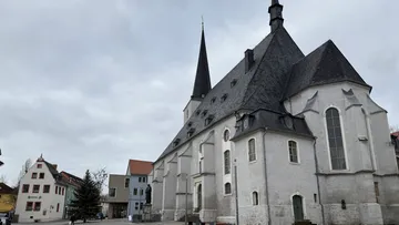 Large church with spire in town square.
