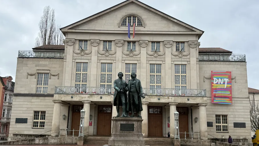 Statue in front of historic theater building.