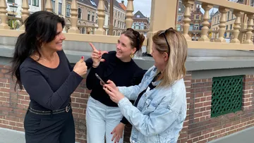 Three women talking and laughing outside.