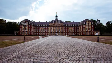 Large historic palace with cloudy sky backdrop.