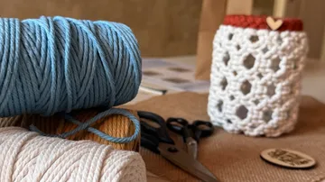 Yarn and crochet jar on crafting table.
