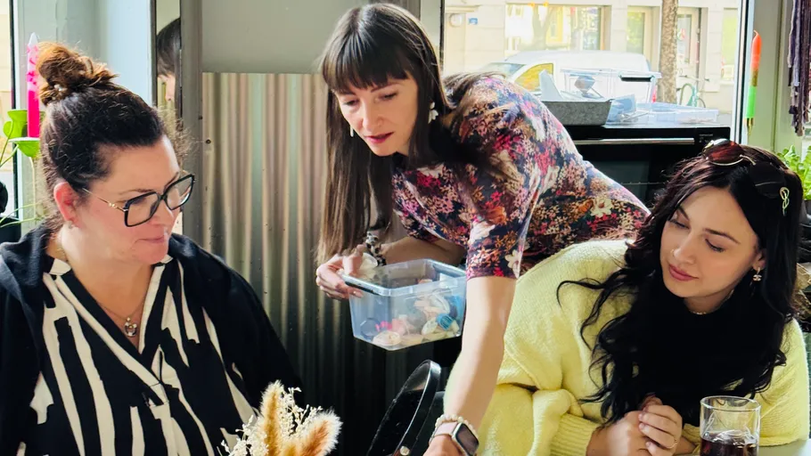 Three women engaging in conversation indoors.