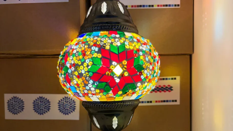 Bunte Mosaiklampe leuchtet hell innen.