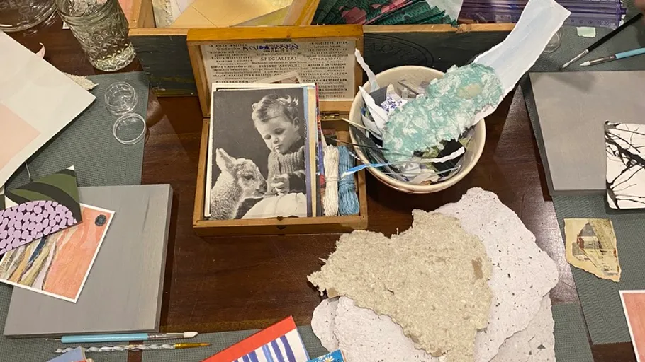 Crafting table with various paper and materials.