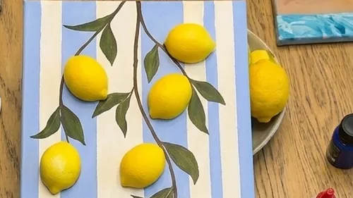 Painted lemons on striped background, wooden surface.