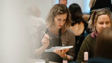 Frau malt in einem vollen Workshop.