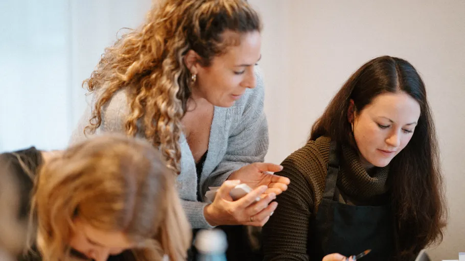 Zwei Frauen besprechen eine Aufgabe drinnen.