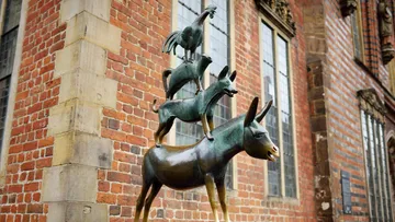 Animal statue stacked in front of brick building.