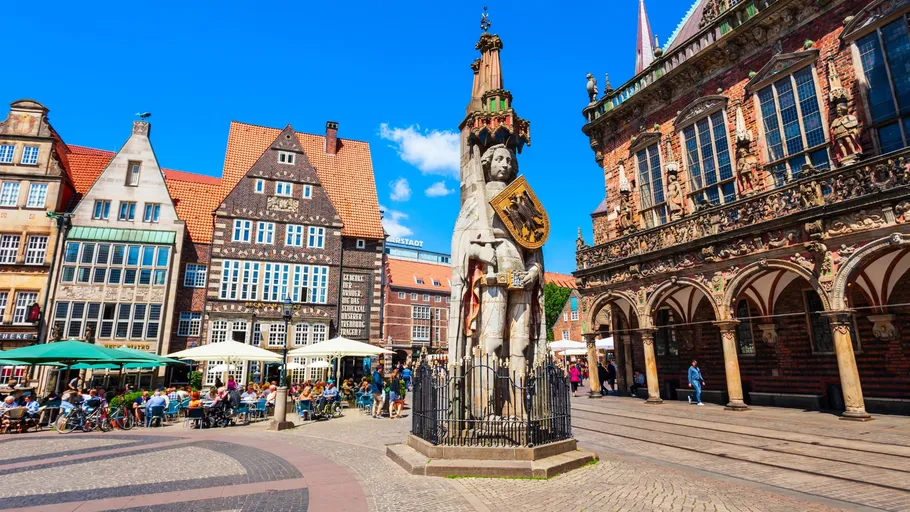 Statue im Stadtplatz mit historischen Gebäuden.