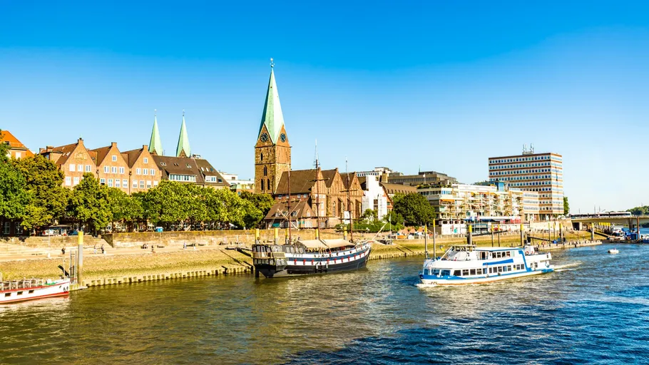 Boats sailing on river by historic buildings.