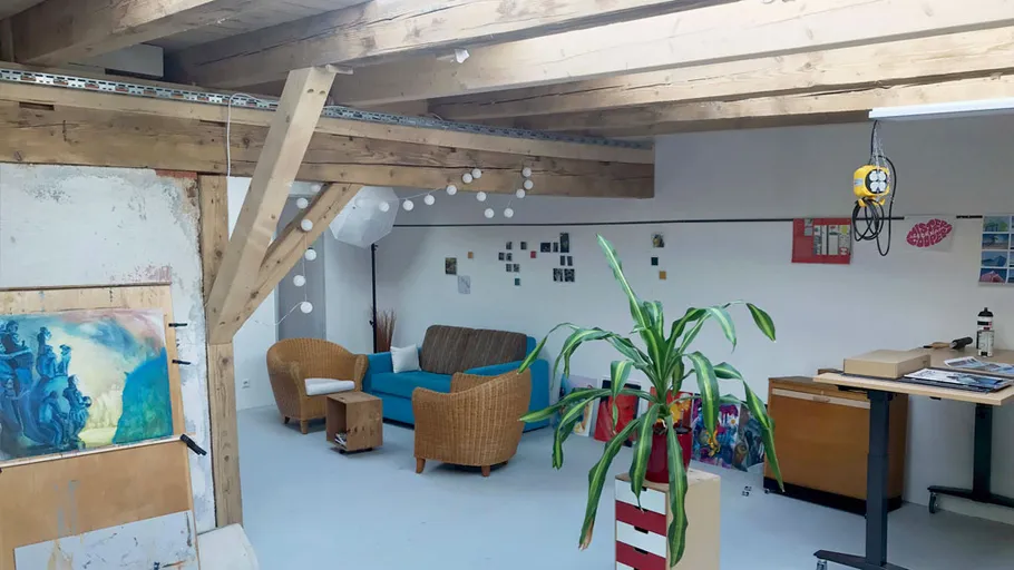Kunststudio mit Stühlen und Gemälden an den Wänden.